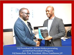 OLIVER TOMLINSON RECEIVING PRESIDENT’S PLAQUE FROM DR. ADRIAN STOKES
